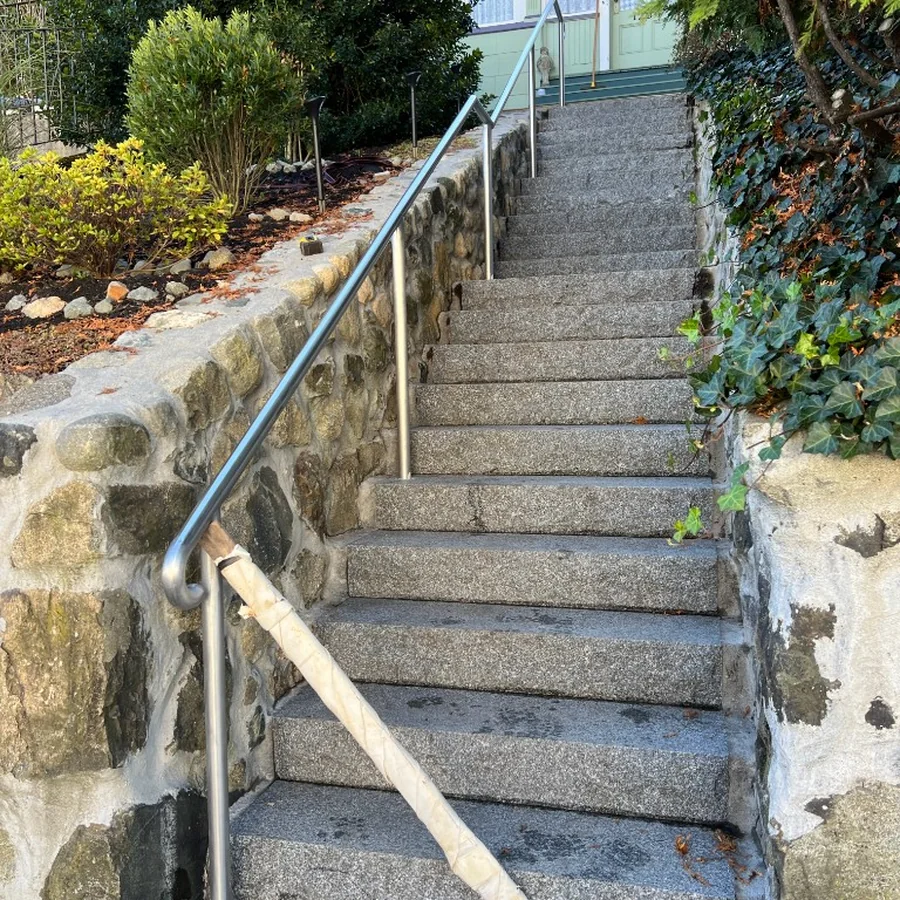 Exterior stair rail installed along stone steps